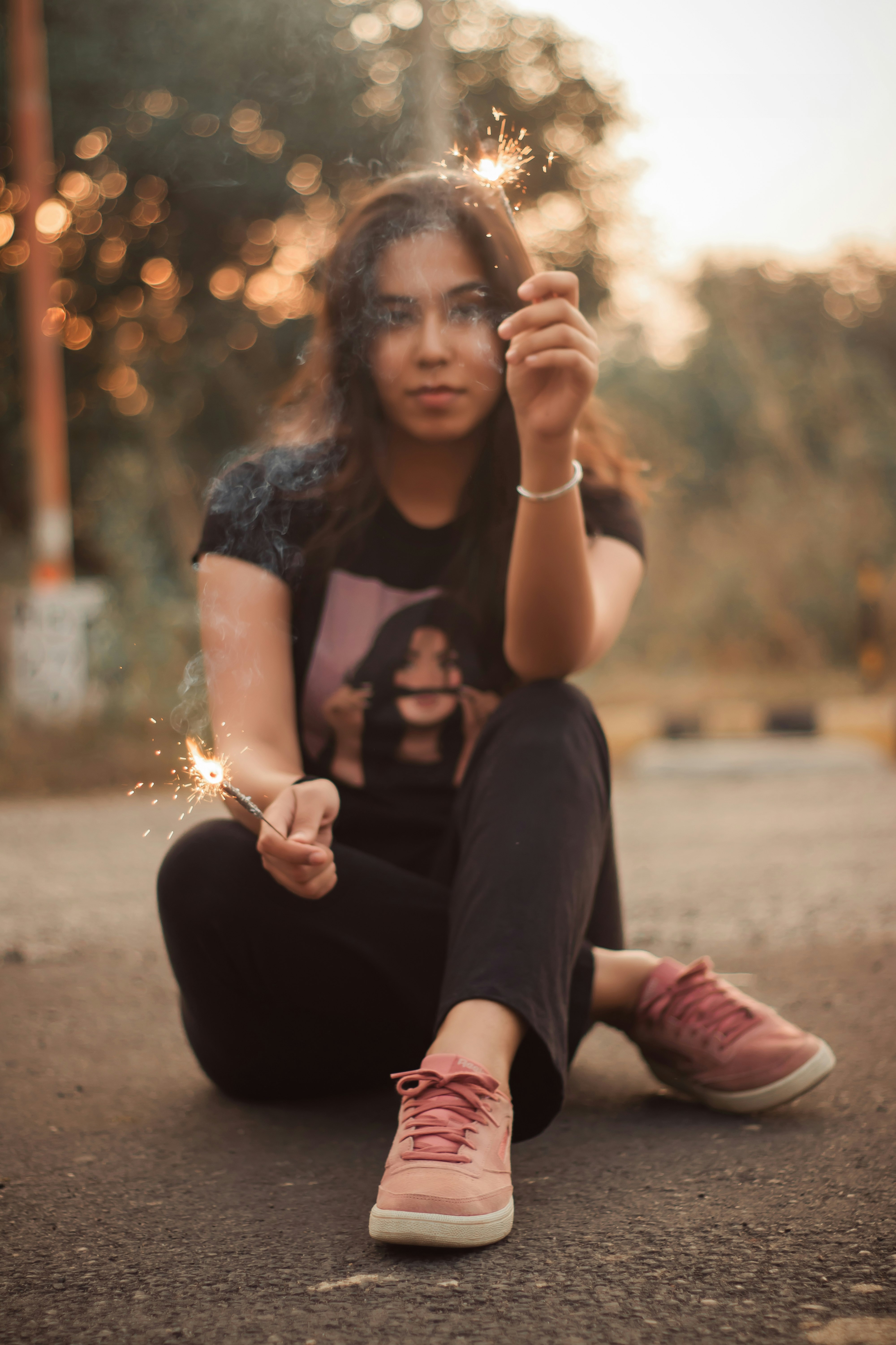 woman in black t-shirt and black pants sitting on ground during daytime